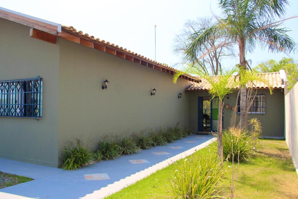 a house with a palm tree in front of it at Casa para temporada com 3 suítes com ar condicionado in Bonito