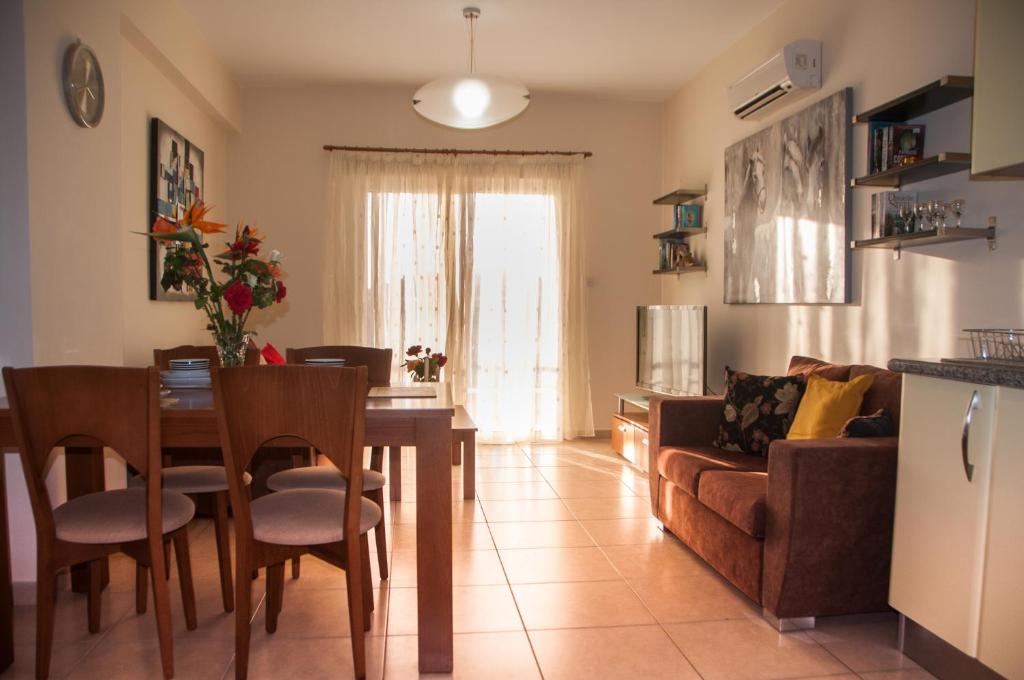 sala de estar con mesa y sofá en Ifestos Kings Resort Appartment, en Pafos