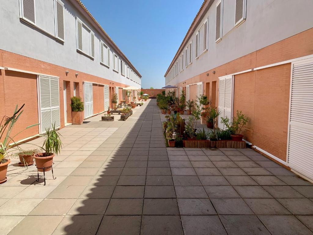 un patio vacío de un edificio con macetas en CASTILLEJA , Casa-Apartamento cerca centro Sevilla Wifi Familias Trabajo Garaje, en Castilleja de la Cuesta