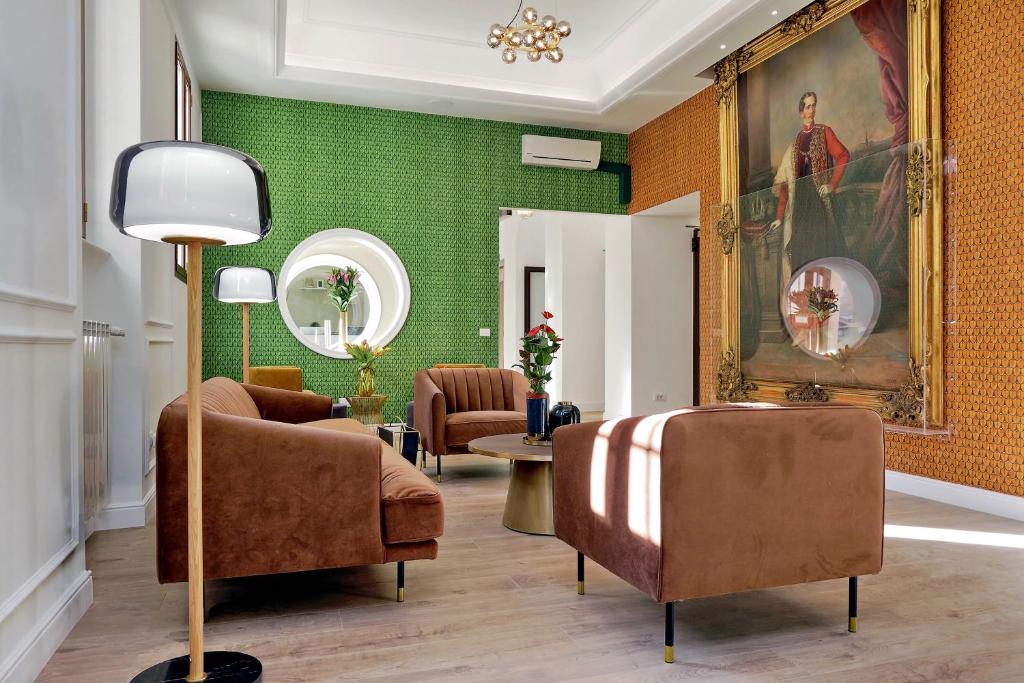 a living room with green walls and brown chairs at Casa Santa Sofia in Rome