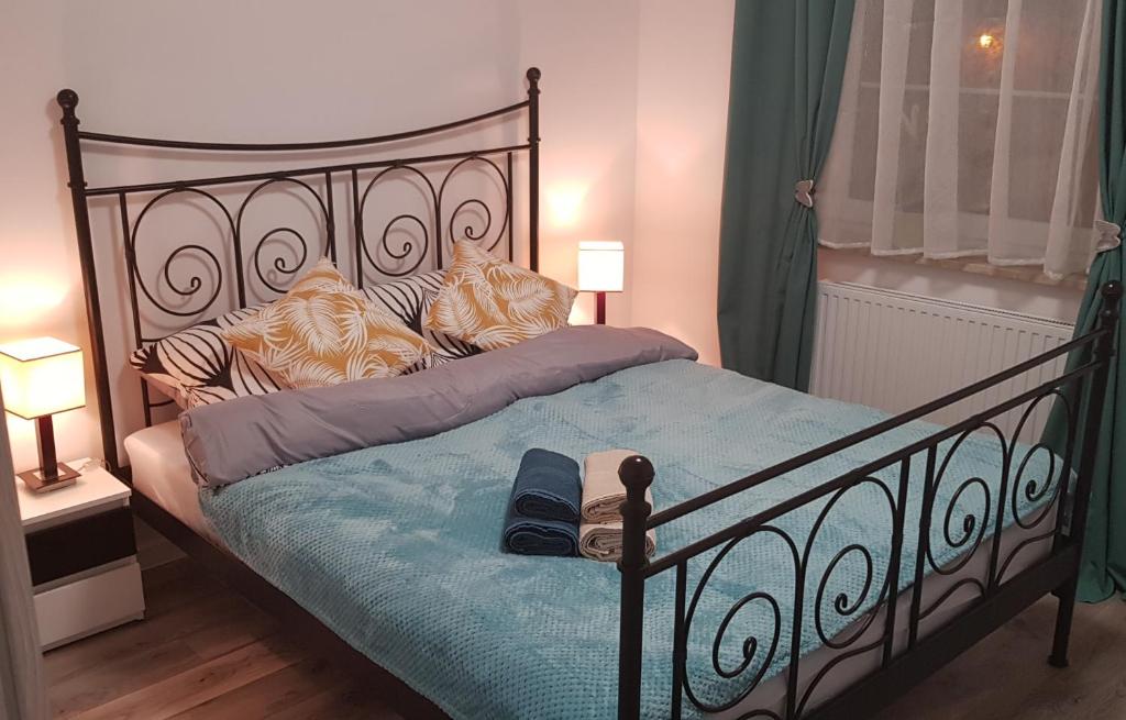 ein Schlafzimmer mit einem schwarzen Bett und einer blauen Decke in der Unterkunft Apartament RODZINNY Wałowa Wejherowo in Wejherowo