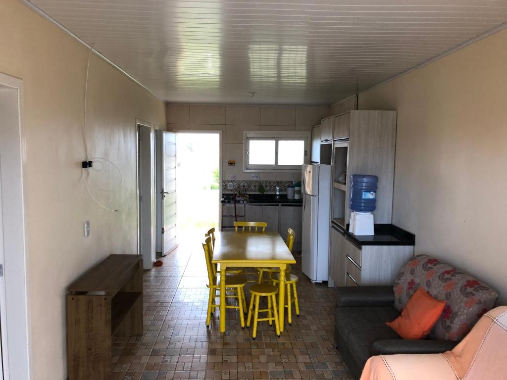 a living room and kitchen with a table and a couch at Casa Praia de Arroio do Sal - Balneário São Paulo in Arroio do Sal