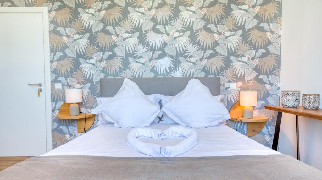 a bed with white sheets and pillows in a bedroom at Sleepyfig in Sagres