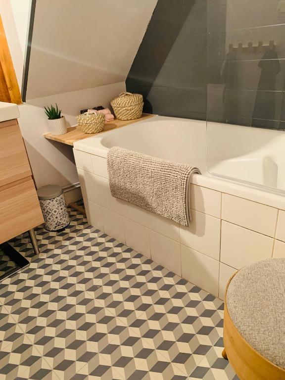 a bathroom with a tub and a checkered floor at La maison de Nina in Sens