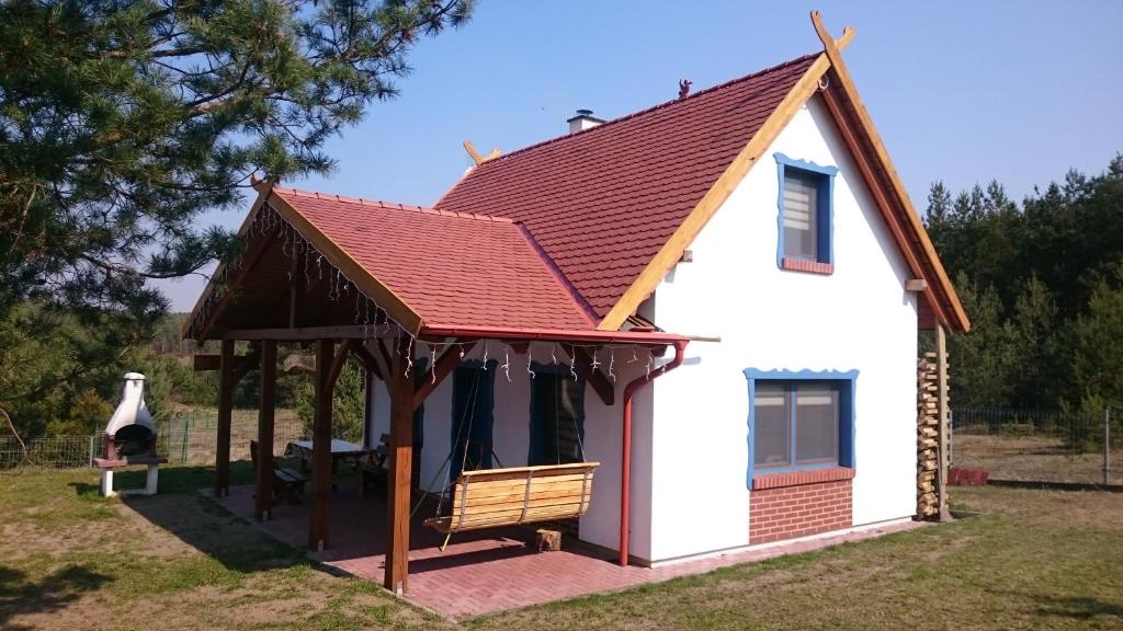 a small white house with a red roof at Domek Smerfna Chatka in Wąglikowice