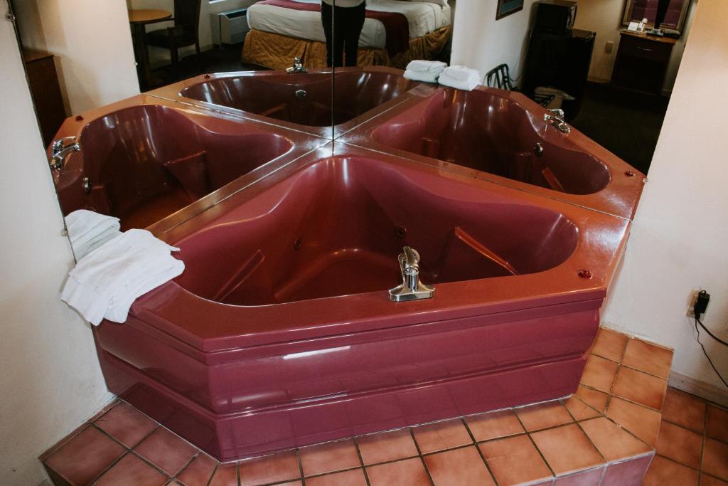 a red tub in a bathroom with a sink at Days Inn By Wyndham Pigeon Forge South in Pigeon Forge