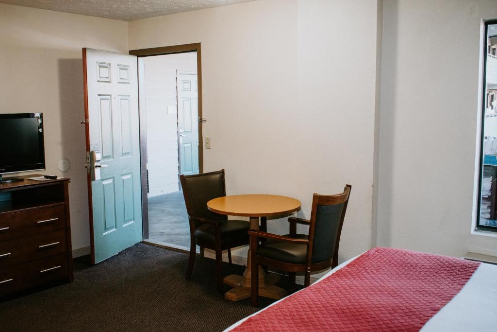 a room with a table and chairs and a television at Days Inn By Wyndham Pigeon Forge South in Pigeon Forge