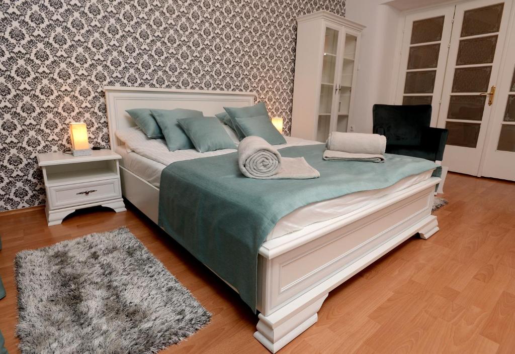een slaapkamer met een groot bed met blauwe kussens bij Bloom apartments in Belgrado