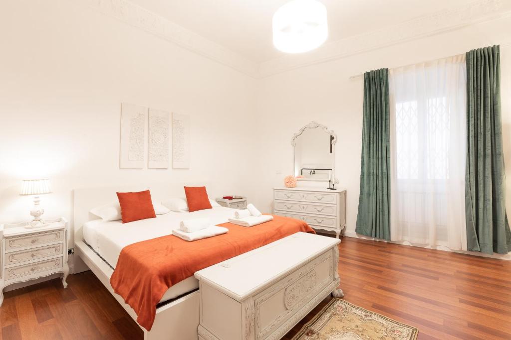 um quarto branco com uma cama com um cobertor laranja em Leonardo Suite Pantheon em Roma