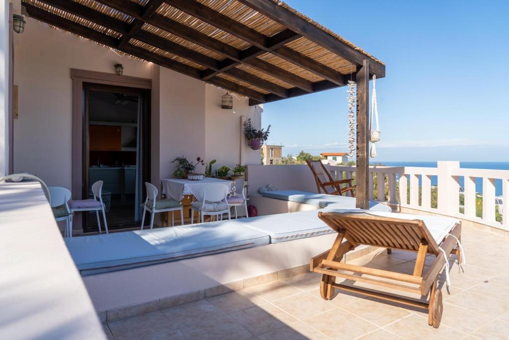 eine Terrasse mit einem Bett, einem Tisch und Stühlen in der Unterkunft Modern Villas with gardens and stunning views in Ligaria