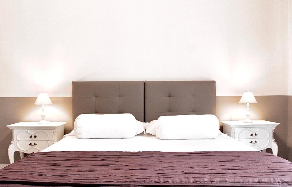 1 dormitorio con 1 cama grande y 2 mesitas de noche blancas en CasaMamy Pompei, en Pompeya