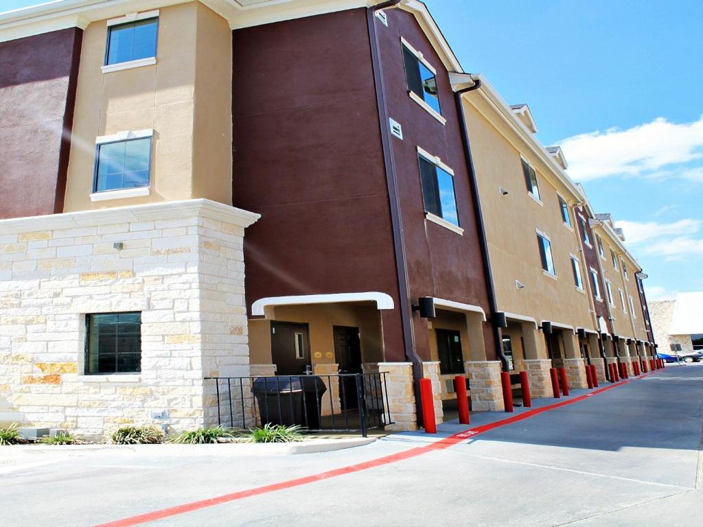 un edificio marrón con postes rojos delante de él en Cityview Inn & Suites Downtown /RiverCenter Area, en San Antonio