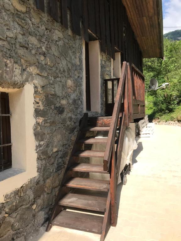 una escalera de madera fuera de un edificio de piedra en AU SOMMET DES NARCISSES, en Albiez-Montrond