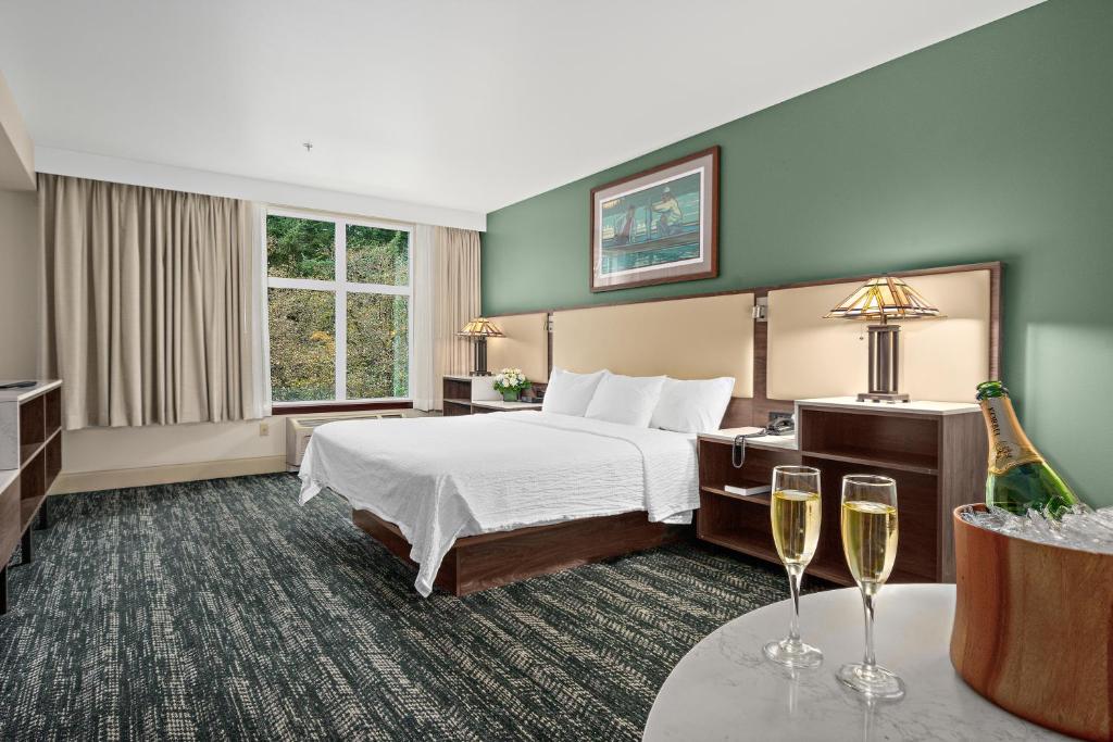 a hotel room with a bed and two glasses of wine at Lucky Eagle Casino & Hotel (Washington) in Rochester