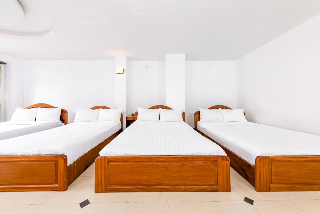a group of three beds in a room at Minh Cat Hotel in Nha Trang