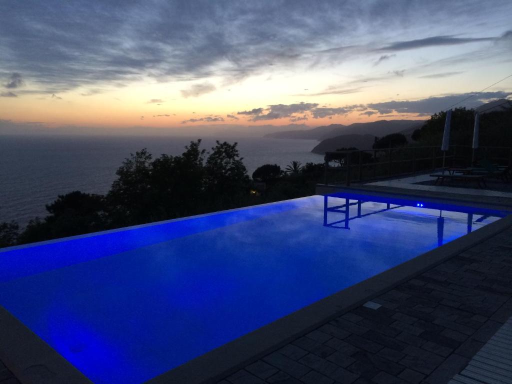 uma piscina azul com vista para o oceano em Hotel La Giada del Mesco em Levanto