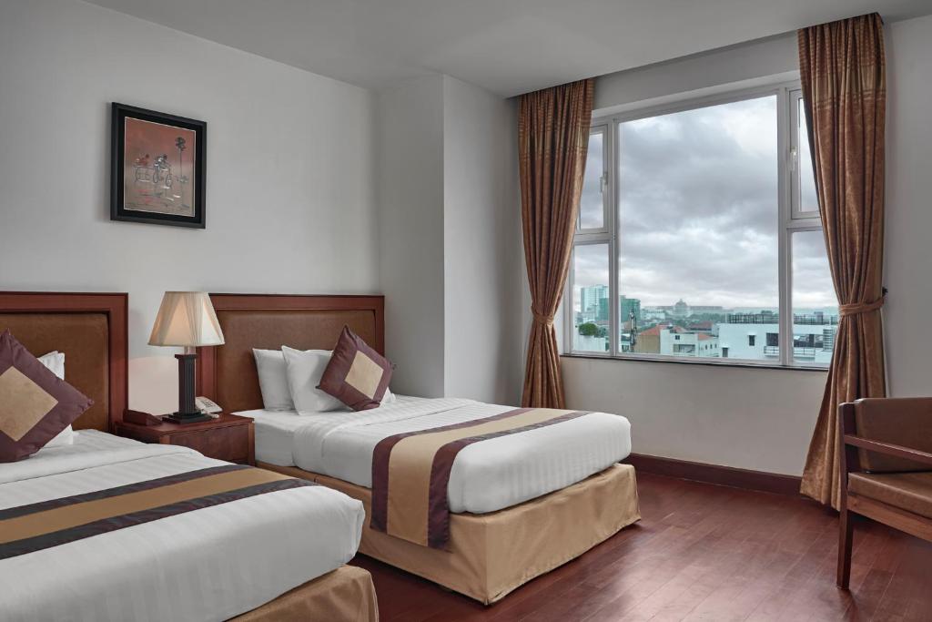 Postel nebo postele na pokoji v ubytování Phnom Penh Katari Hotel
