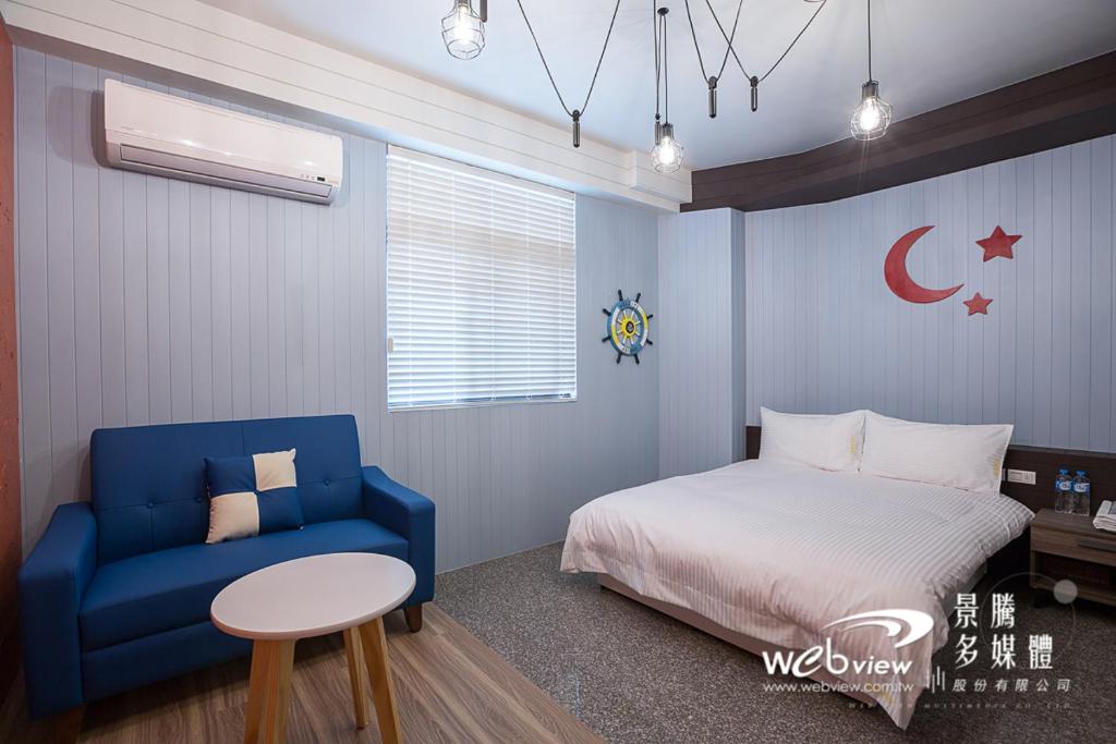 ein Schlafzimmer mit einem Bett und einem blauen Stuhl in der Unterkunft FDBK Homestay in Dongshan