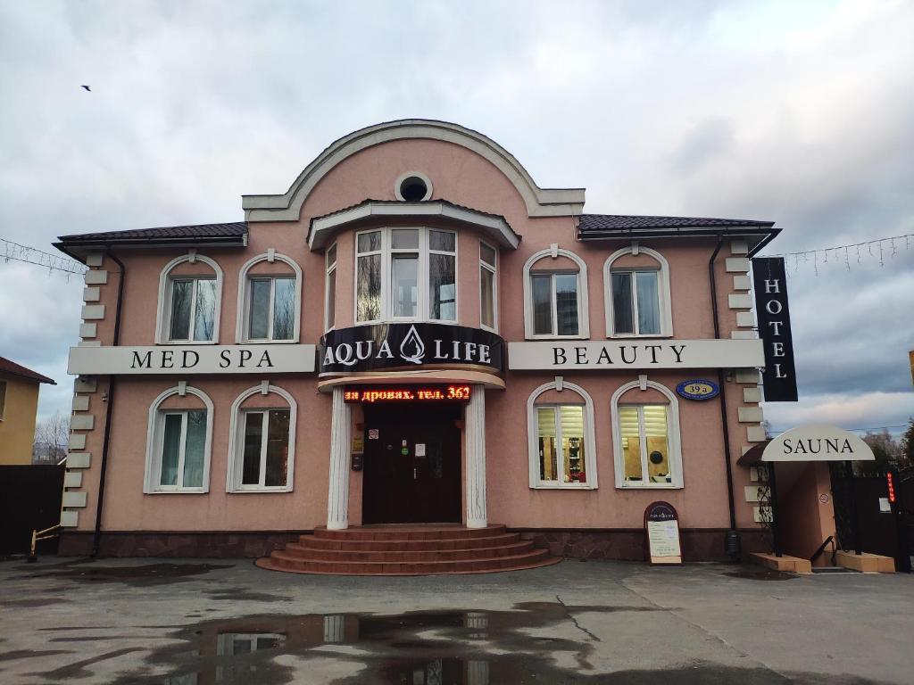 チェボクサルにあるAqualife Spa hotel on Leninskogo Komsomolaのピンクの建物(医療スパ、美容室付)