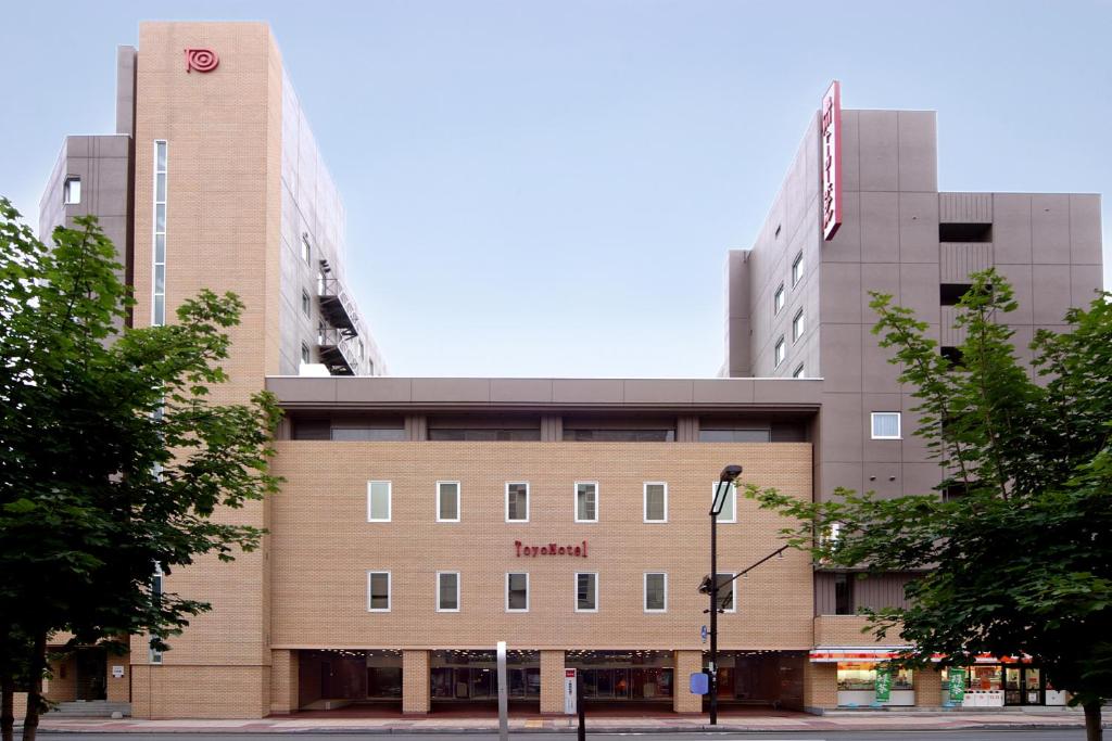 Un bâtiment avec un panneau en haut dans l'établissement Asahikawa Toyo Hotel, à Asahikawa