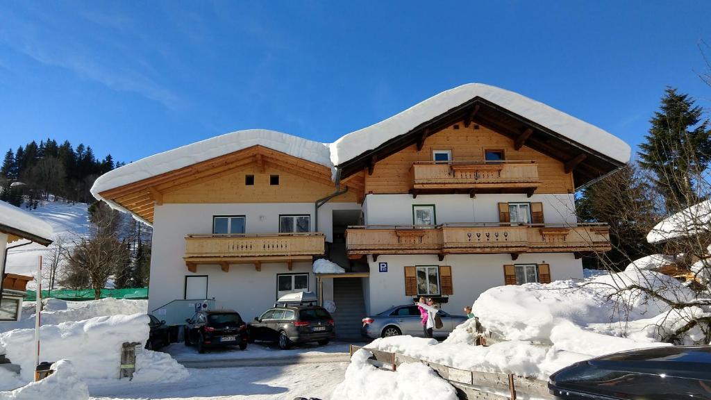 ein großes Gebäude mit einem schneebedeckten Dach in der Unterkunft Appartement Ingrid in Ellmau