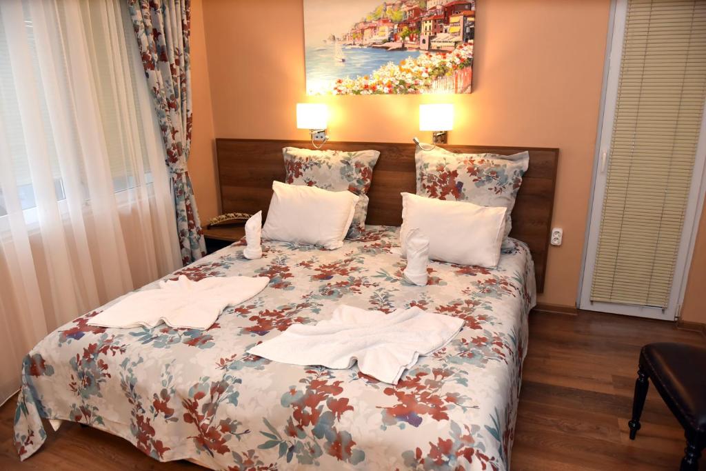 1 dormitorio con 1 cama con toallas en City apartments en Varna