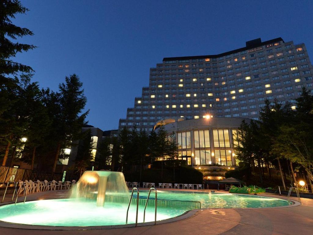 ein großes Gebäude mit einem Brunnen vor einem Gebäude in der Unterkunft Hotel Listel Inawashiro Wing Tower in Inawashiro