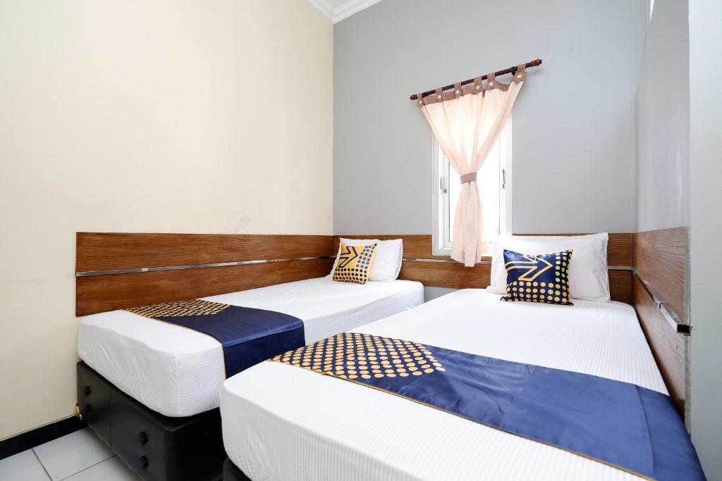 Postel nebo postele na pokoji v ubytování SUPER OYO 2209 Solo Point Guest House Syariah