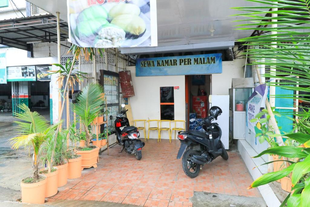 BalangberuにあるTechno Innの小さなキッチン唐辛子屋の外に停まったスクーター2台