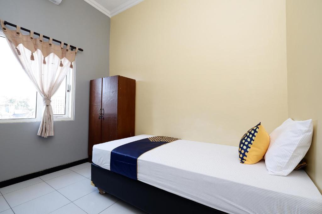 Postel nebo postele na pokoji v ubytování SUPER OYO 2209 Solo Point Guest House Syariah