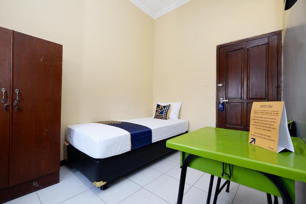 Postel nebo postele na pokoji v ubytování SUPER OYO 2209 Solo Point Guest House Syariah