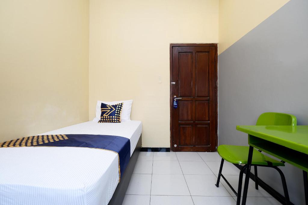 Postel nebo postele na pokoji v ubytování SUPER OYO 2209 Solo Point Guest House Syariah