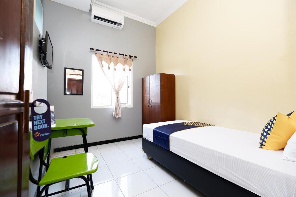 Postel nebo postele na pokoji v ubytování SUPER OYO 2209 Solo Point Guest House Syariah