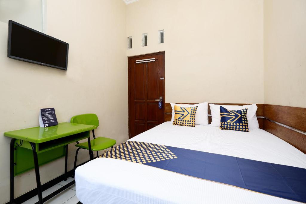 Postel nebo postele na pokoji v ubytování SUPER OYO 2209 Solo Point Guest House Syariah