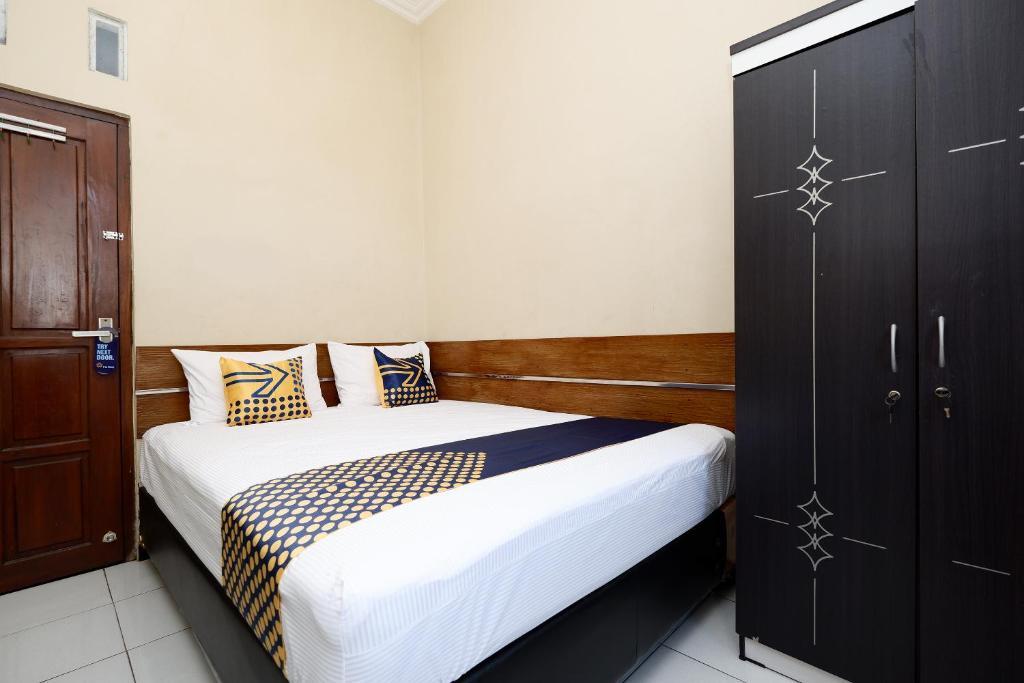 Postel nebo postele na pokoji v ubytování SUPER OYO 2209 Solo Point Guest House Syariah