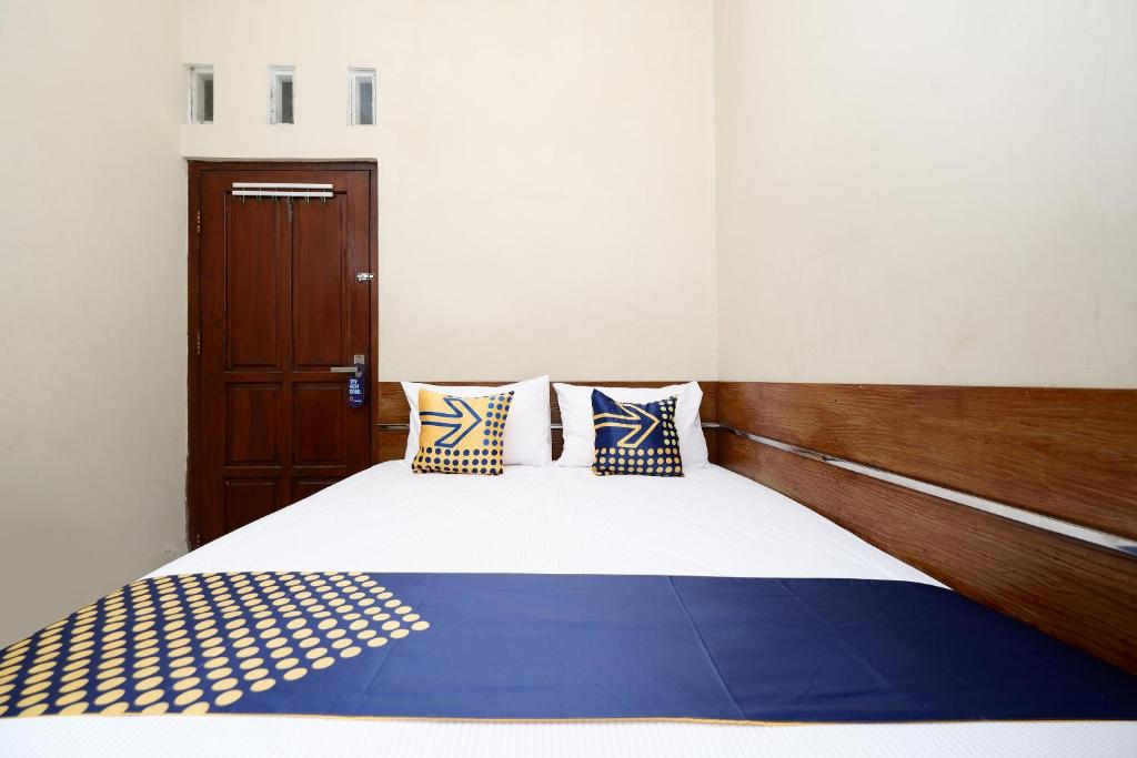 Postel nebo postele na pokoji v ubytování SUPER OYO 2209 Solo Point Guest House Syariah