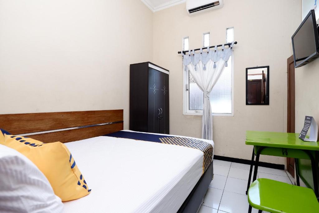 Postel nebo postele na pokoji v ubytování SUPER OYO 2209 Solo Point Guest House Syariah
