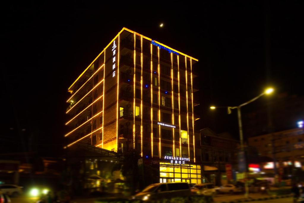 Un grand bâtiment avec des lumières allumées la nuit dans l'établissement Junlan Hotel, à Sihanoukville