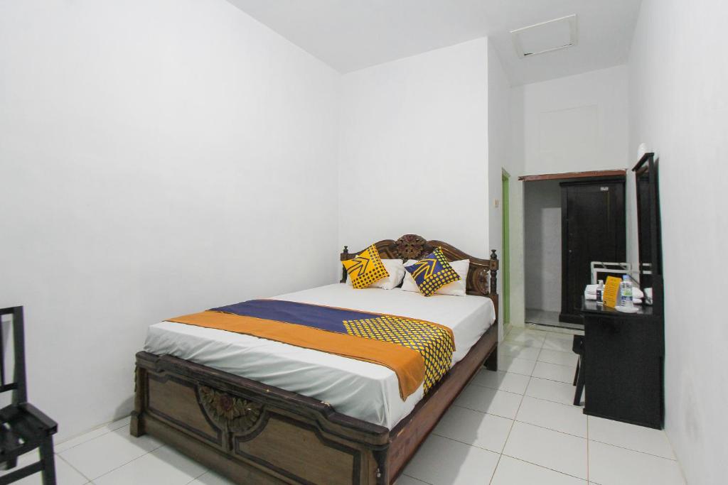 1 dormitorio con 1 cama en una habitación blanca en OYO 2042 Zam Zam Family Syariah en Ketapang