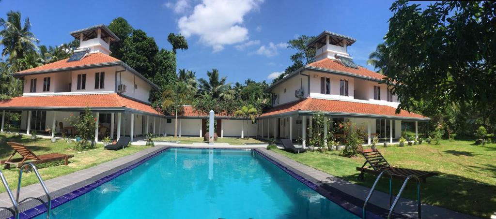 una casa con piscina frente a ella en Anuhas Airport Villas en Katunayaka