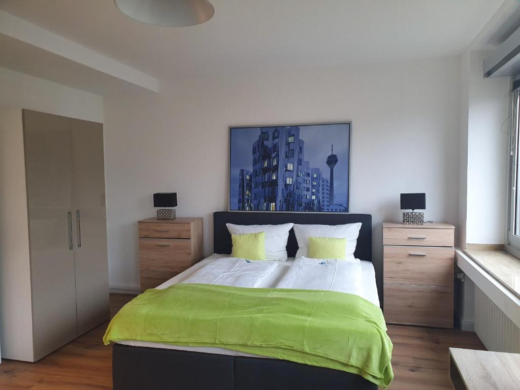 um quarto com uma cama grande e um cobertor verde em Studiotel TOP LOFT em Düsseldorf
