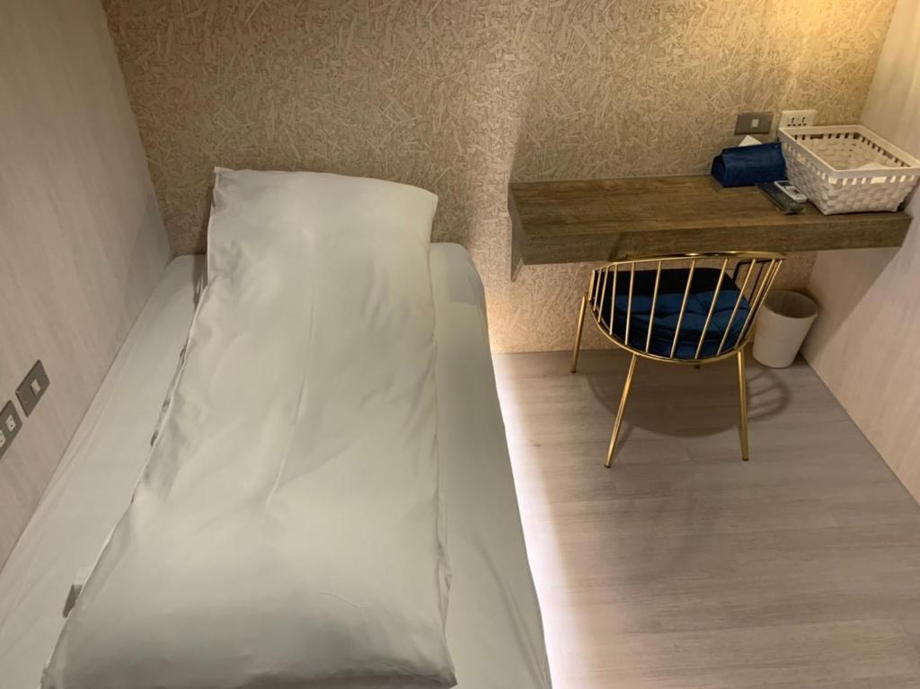 a bed in a room with a table and a chair at York Hotel in Taipei