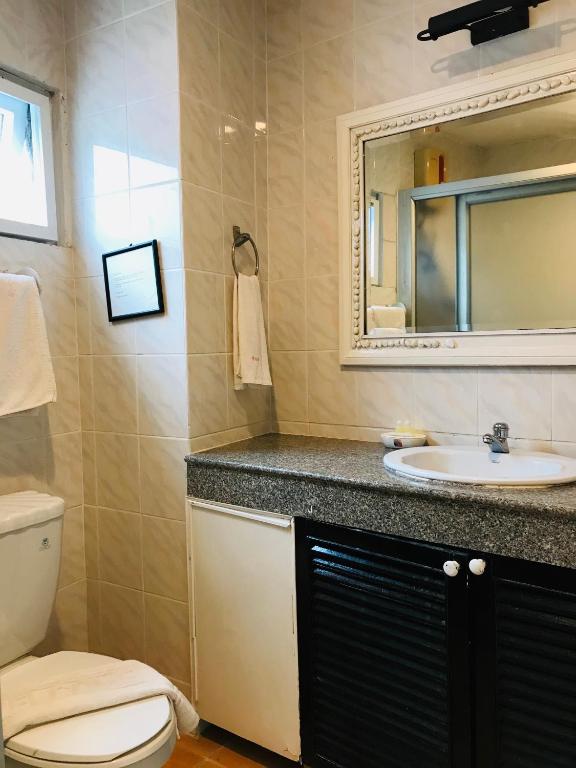 ein Badezimmer mit Waschbecken, Toilette und Spiegel in der Unterkunft Orchid Hotel and Spa Kalim Bay in Patong Beach