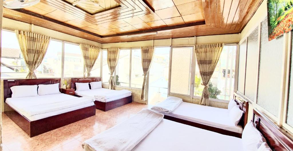 Habitación con 2 camas y ventanas. en Thanh Thao Dalat Hotel, en Da Lat
