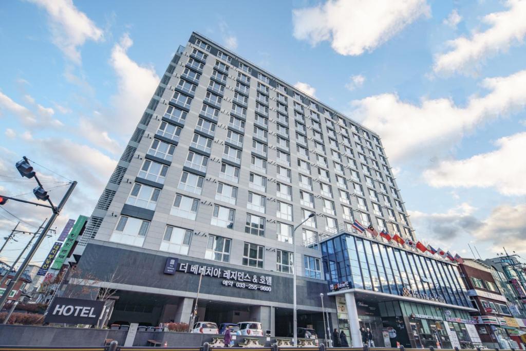 a tall white building in the middle of a city at The Venezia Suite Hotel in Chuncheon