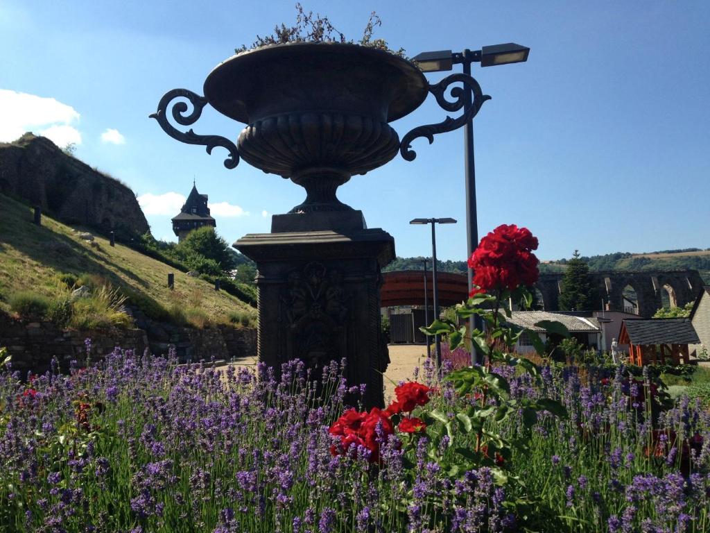 a statue in the middle of a garden with flowers at Rhine Pearl Hideaways in Oberwesel