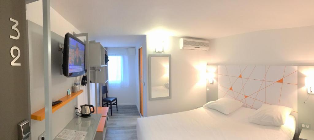 - une chambre avec un lit blanc et une télévision dans l'établissement Hotel du Parc Euromédecine by AKENA, à Montpellier