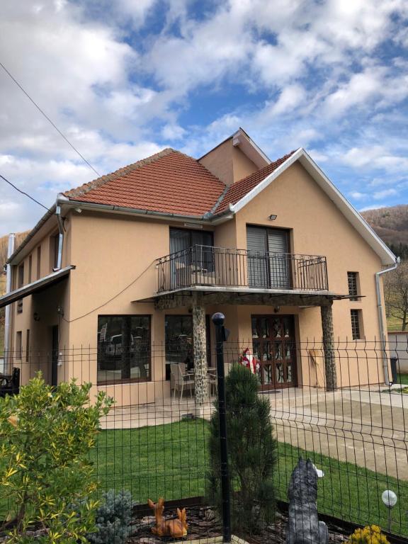 a house with a fence in front of it at Casa Larisa in Chişcău