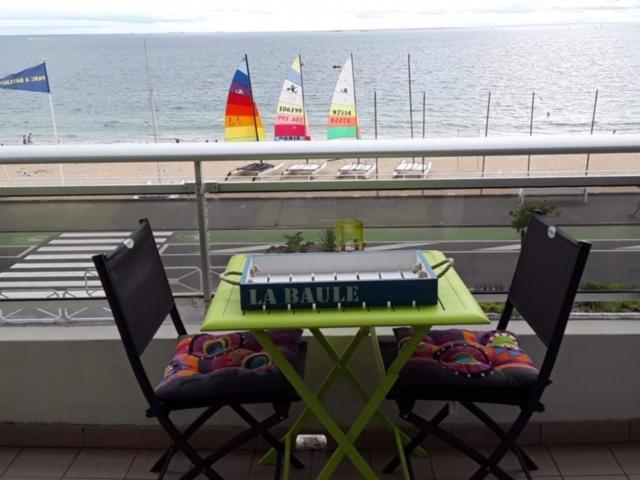 - une table et des chaises sur un balcon avec voiliers dans l'établissement Face Mer 