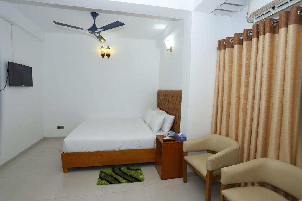 una camera d'albergo con letto e sedia di Hotel Blue Castle a Dhaka